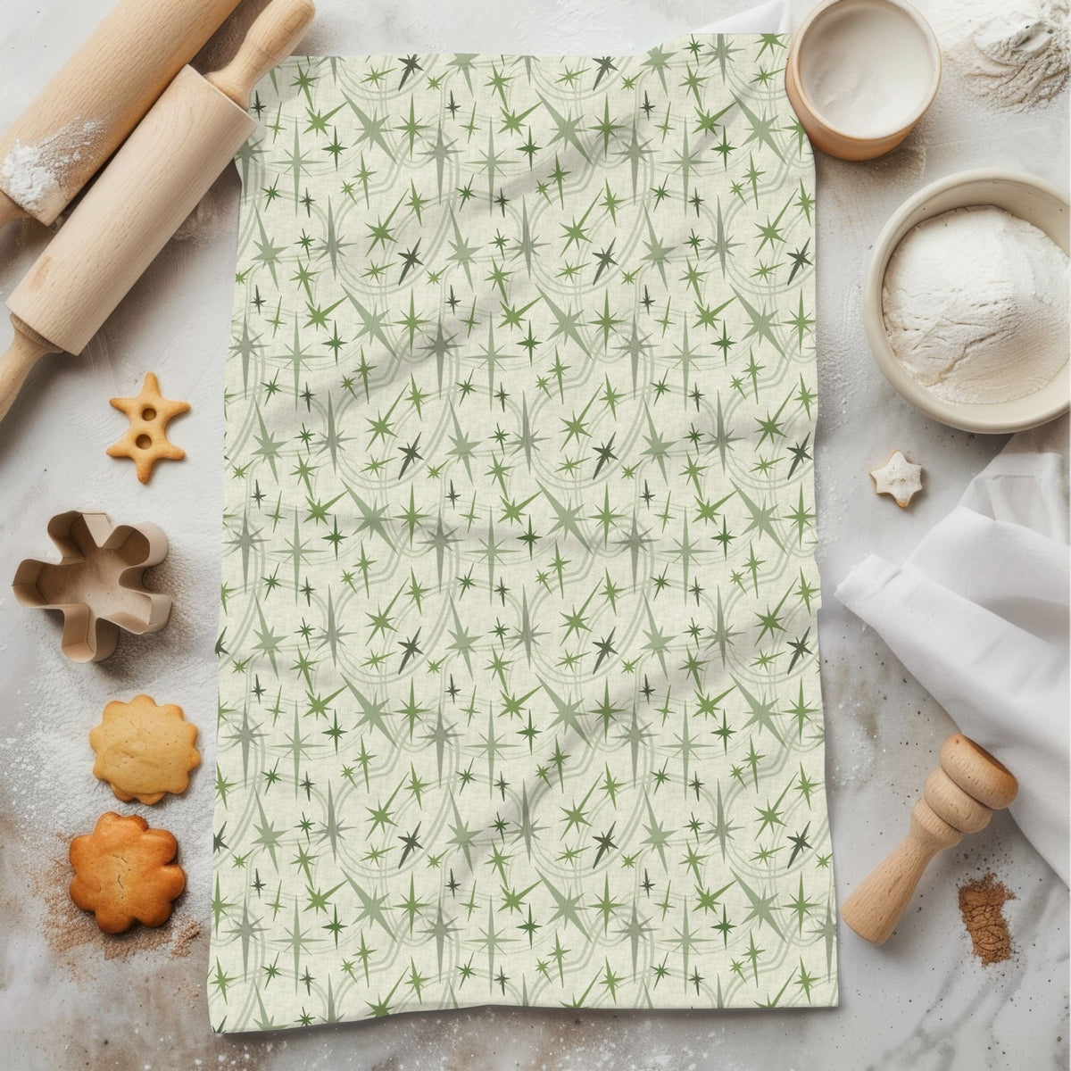 Sage green retro olive tea towel with mid-century portrait repeat pattern, styled flat on marble surface with rolling pin and cookies