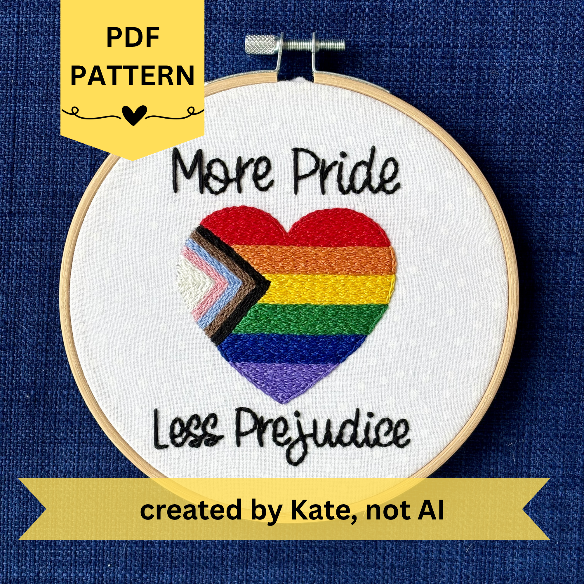 PDF pattern created by Kate, not AI. "More Pride Less Prejudice." Text in script font and hand embroidered in black. Words are placed above and below a heart shaped progress pride flag. Rainbow heart flag includes white, pink, light blue, brown, black, red, orange, yellow, green, blue, and purple stripes. Fabric is white cotton with white polka dots. Framed as wall art in light wood embroidery hoop.