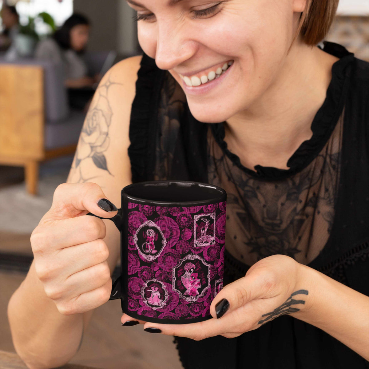 Smiling woman in a black lace top holding a hot pink zombie portrait gallery mug in a bright coffee shop