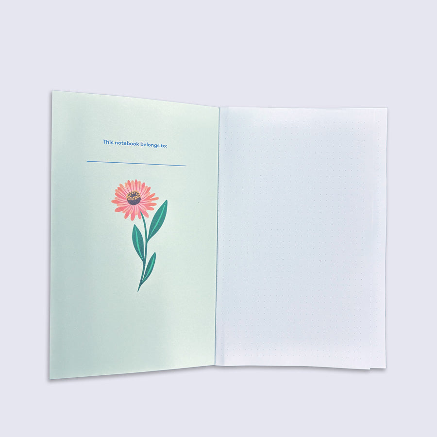 Open notebook with a flower illustration on a light green page.