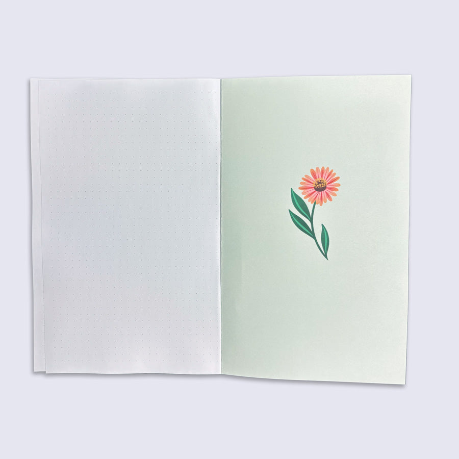 Open notebook with a pink flower illustration on a light green page