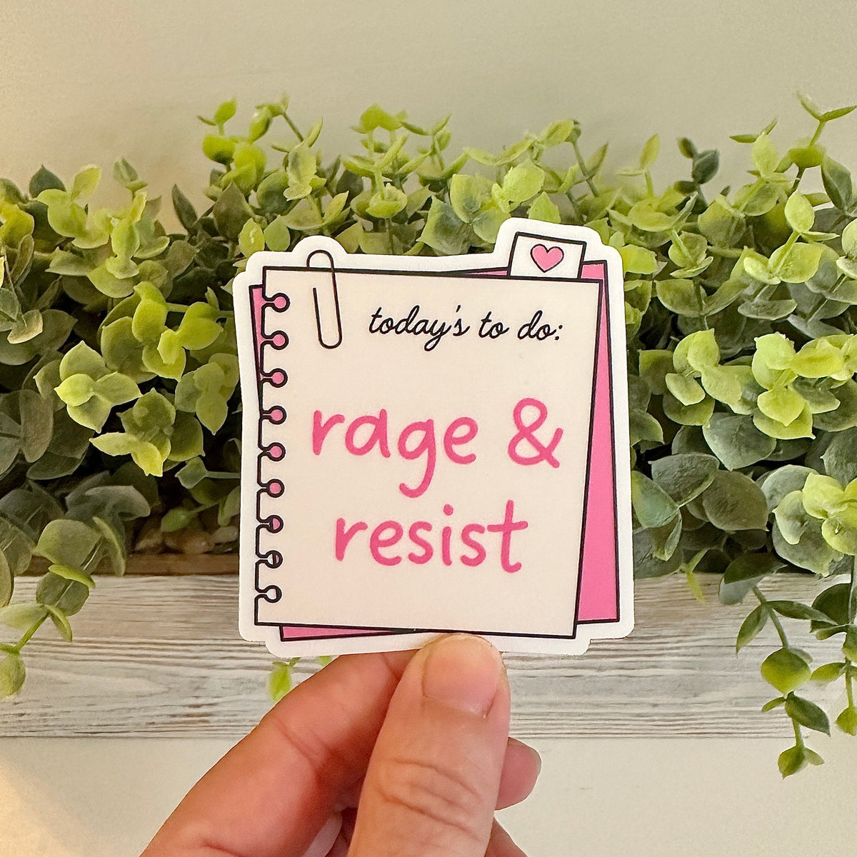 Hand holding a sticker with &