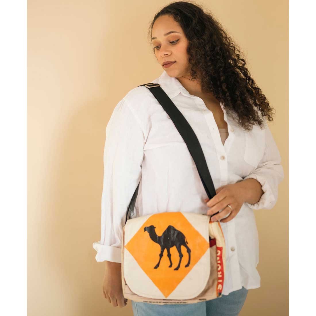 woman wearing small sustainable messenger bag - camel design
