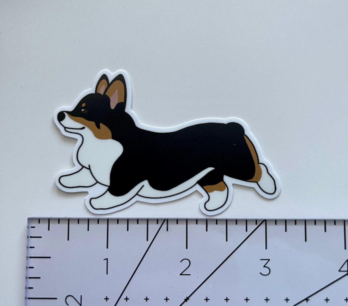 Running Corgi Sticker flat lay — cute corgi laptop and water bottle sticker, dog mom gift by indie artist MangoIllustrated