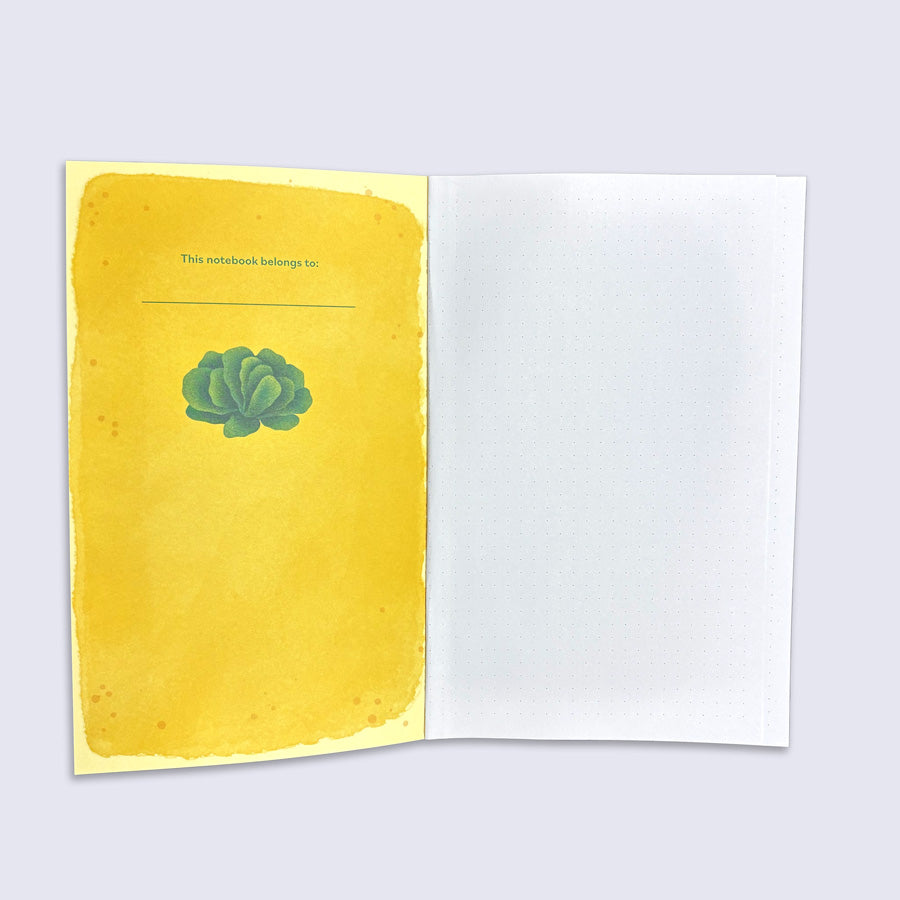 Notebook with yellow cover and green lettuce illustration on a light gray background