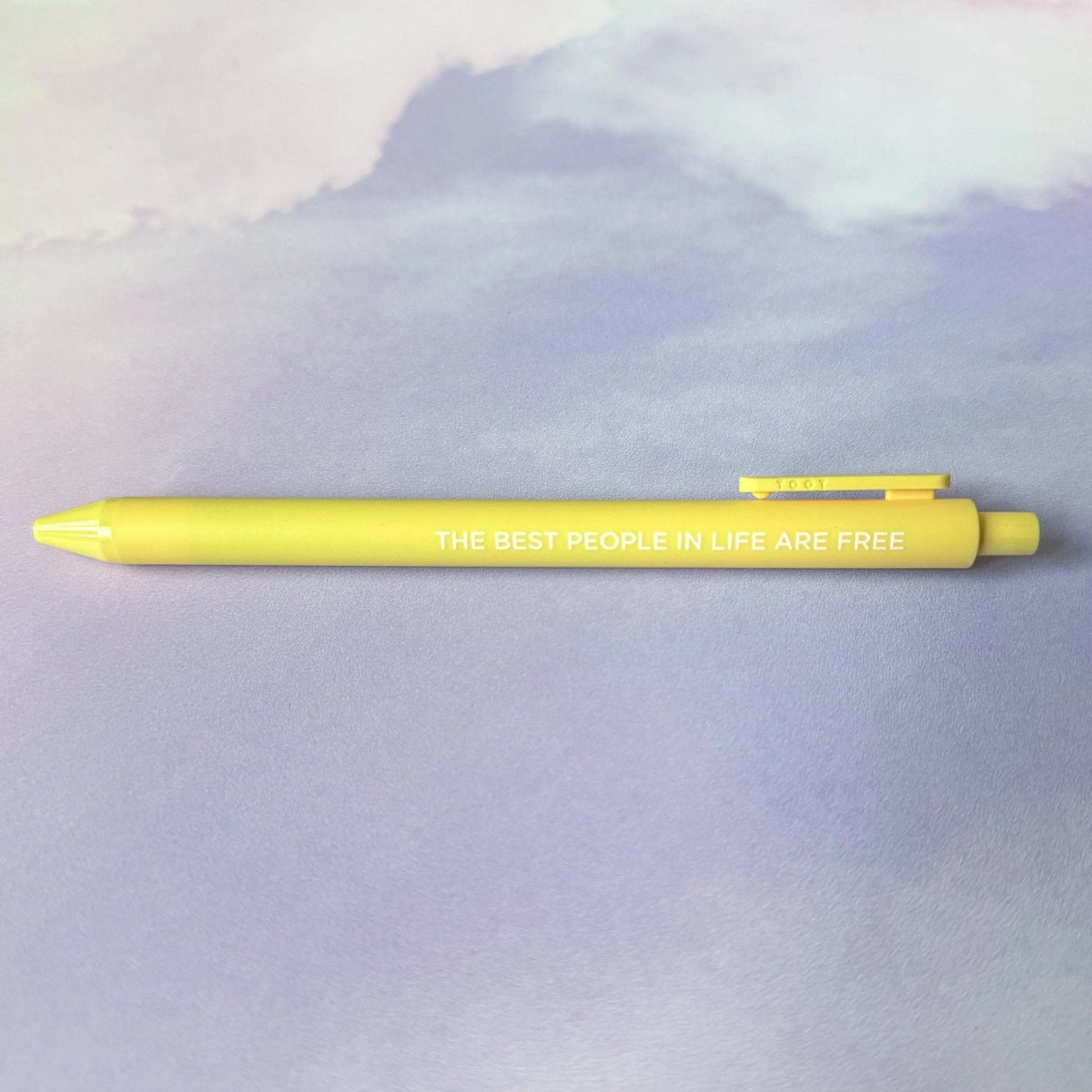 The Best People in Life Are Free jotter pen flat lay — banana yellow barrel 1989 era desk pen by indie artist MangoIllustrated