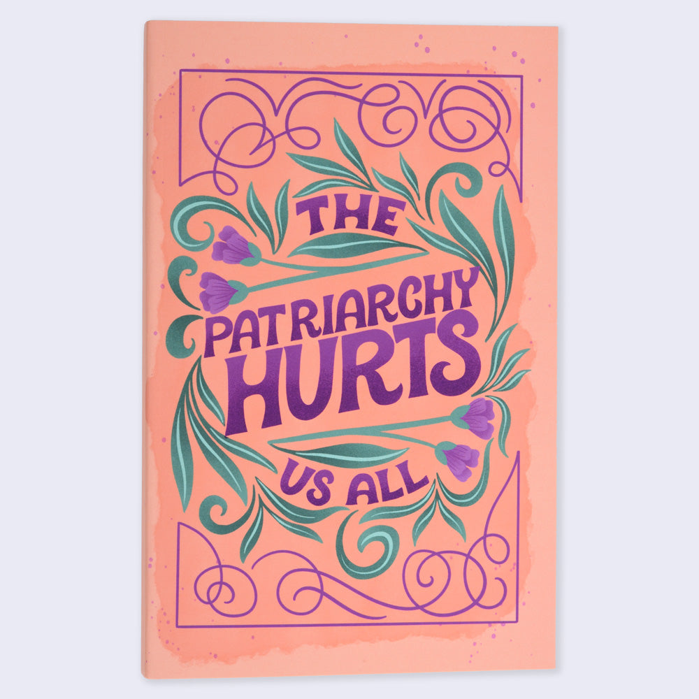 A flat lay image of a notebook with an orange cover featuring a purple-colored floral and text design, with the title &