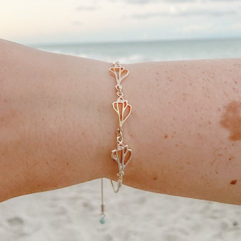the beach and back plum island triple slider bracelet on wrist with beach and ocean in the background