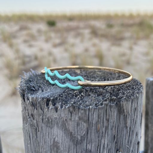 the beach and back signature wave bracelet on textured wood post at beach