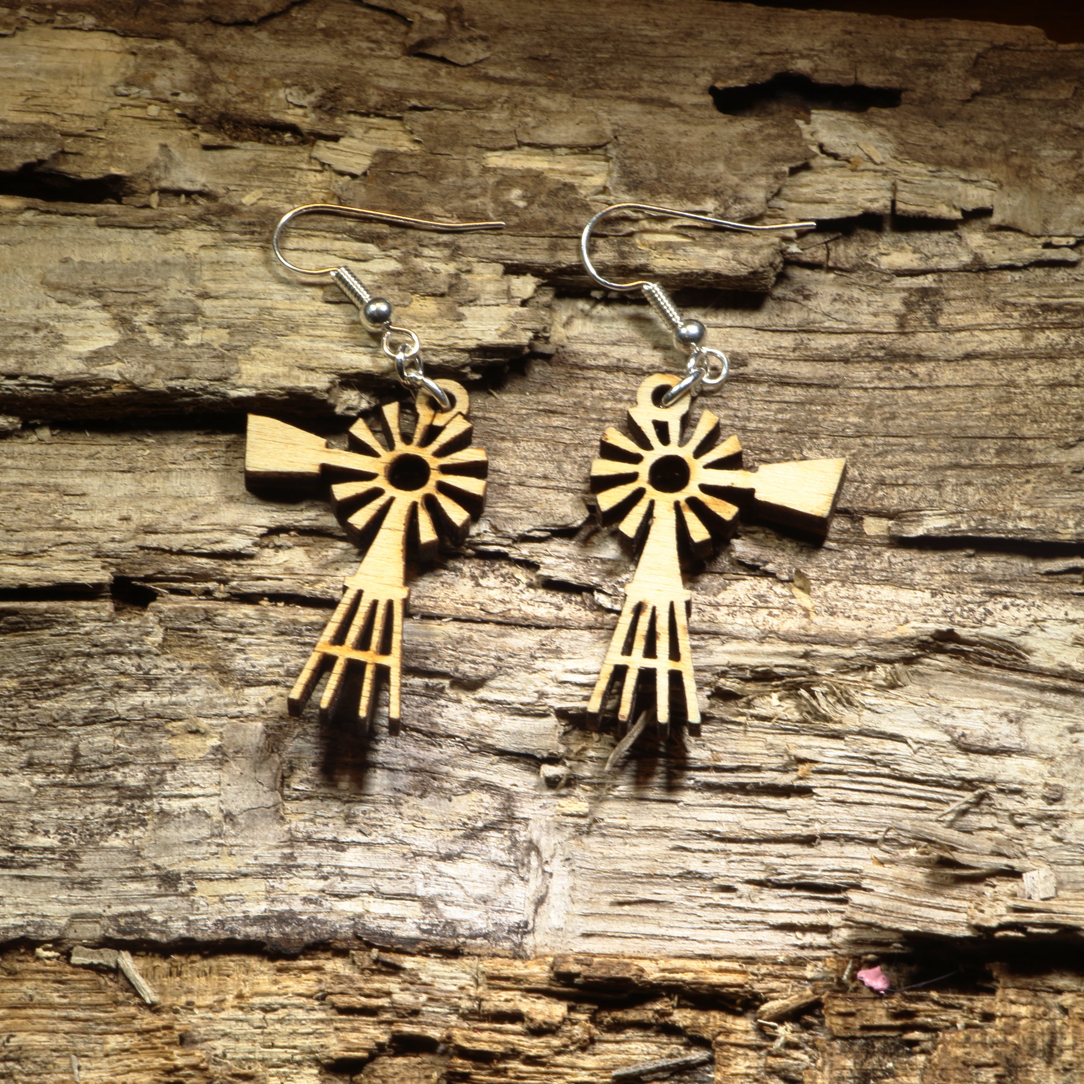 Hand-painted wooden windmill dangle earrings featuring a classic rustic windmill silhouette with detailed laser-cut blades. Crafted from lightweight wood with hypoallergenic .925 sterling silver hooks, these charming earrings are perfect for farmhouse décor lovers, country living enthusiasts, western style fans, rural Americana collectors, and anyone who appreciates unique rustic-inspired jewelry.