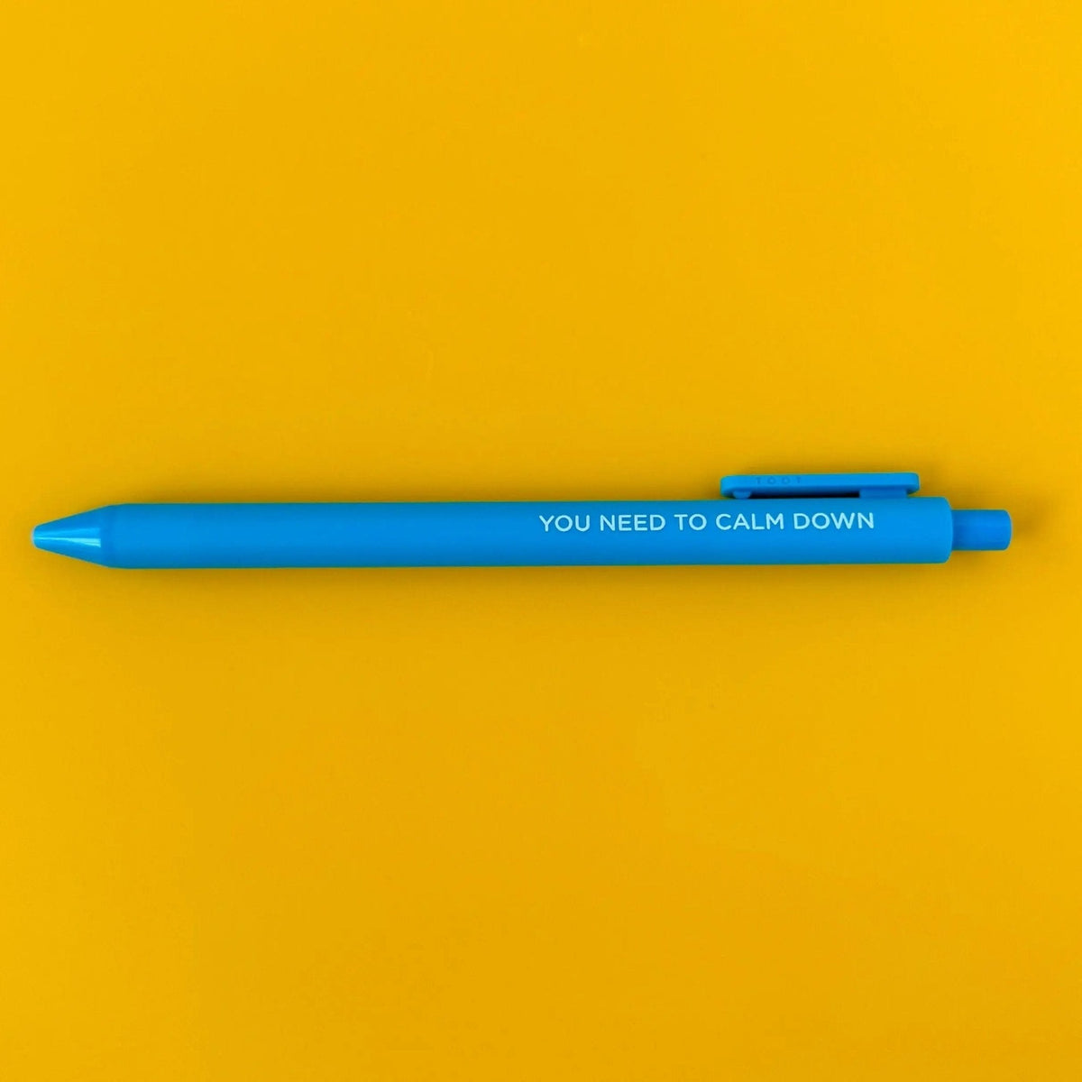 You Need to Calm Down pen detail — embossed lyric lettering on a bright blue barrel by indie artist MangoIllustrated