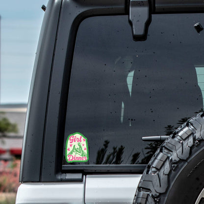 Car window with a sticker and tire visible outdoors
