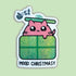 A die-cut sticker featuring a cute pink cartoon cat peeking over a glittery green Christmas gift box, with a small sleigh and stars above and the text &