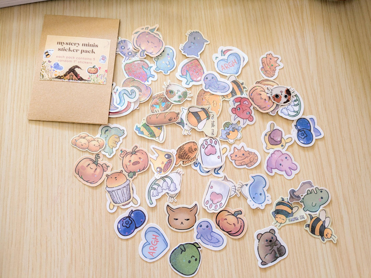 Collection of colorful stickers on a wooden surface with a small box labeled &