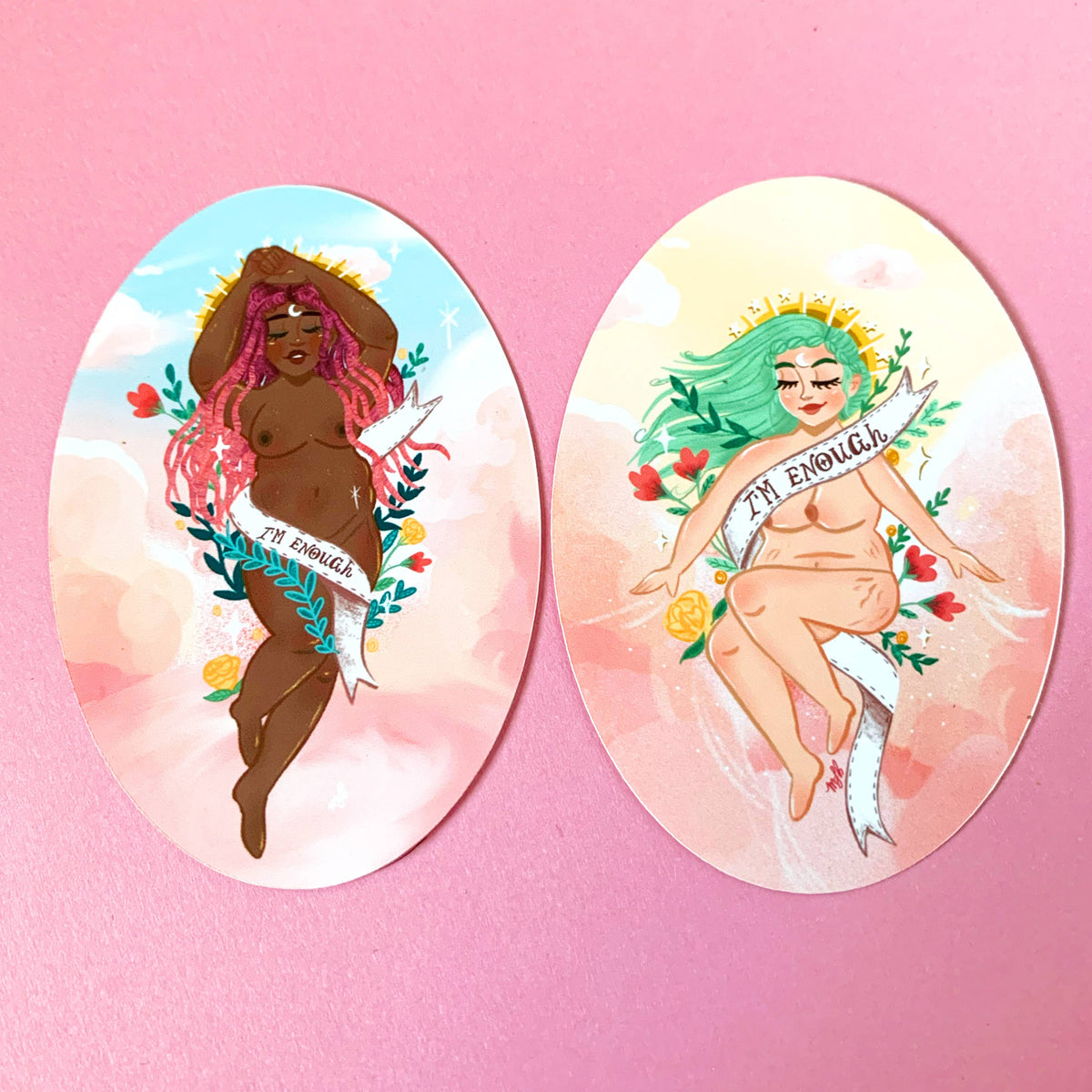 Two oval art prints or stickers displayed side-by-side on a solid pink background. The left print features a dark-skinned woman with pink hair and the text &