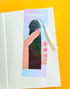 Decorative bookmark with tassel on a book against a yellow background