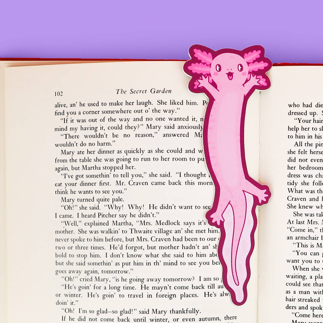 Pink axolotl-shaped bookmark on an open book with a purple background