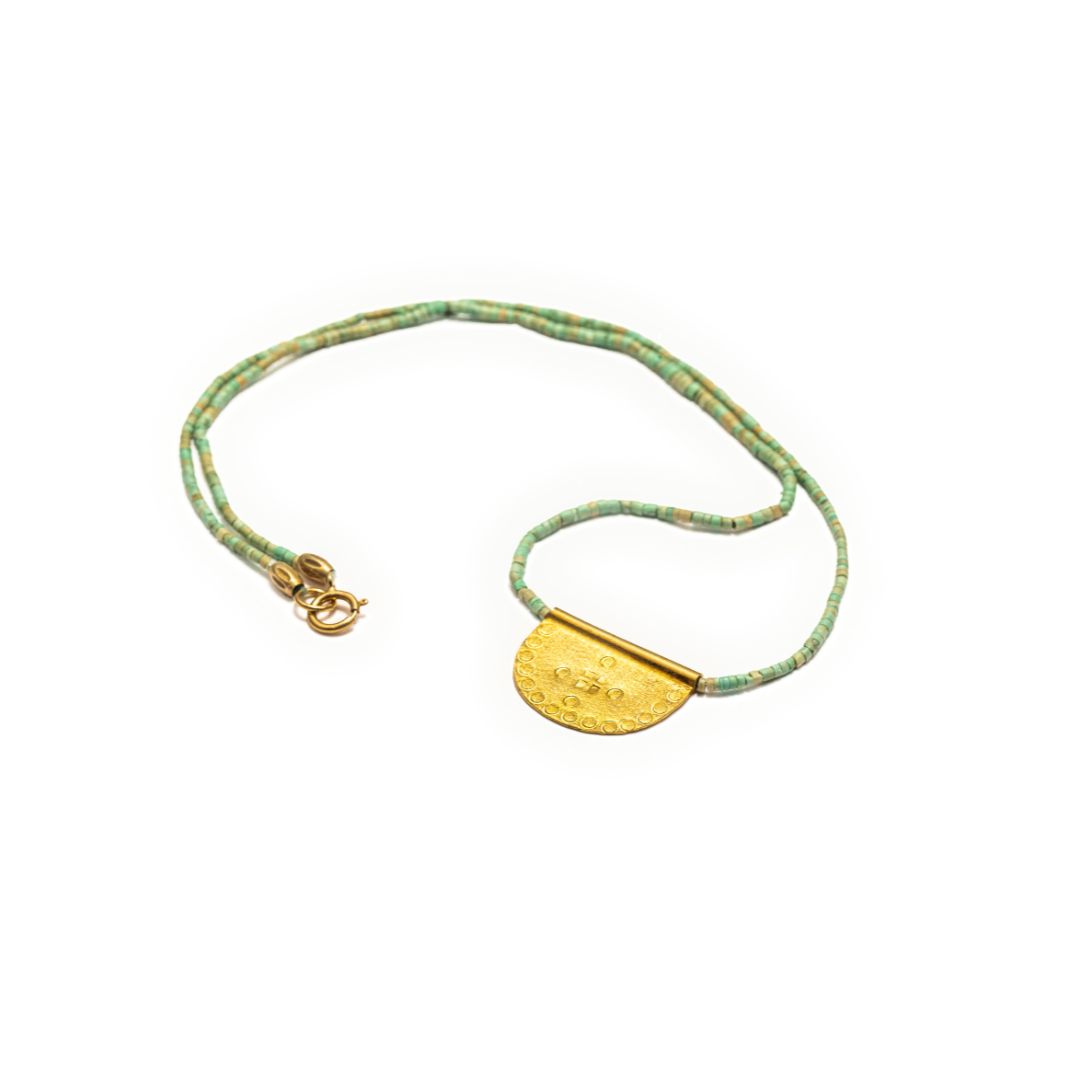 Artisan made turquoise beads and gold vermeil stamped pendant, from mexico, flat lay