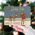 A hand holds a vintage-style Christmas card featuring the text &