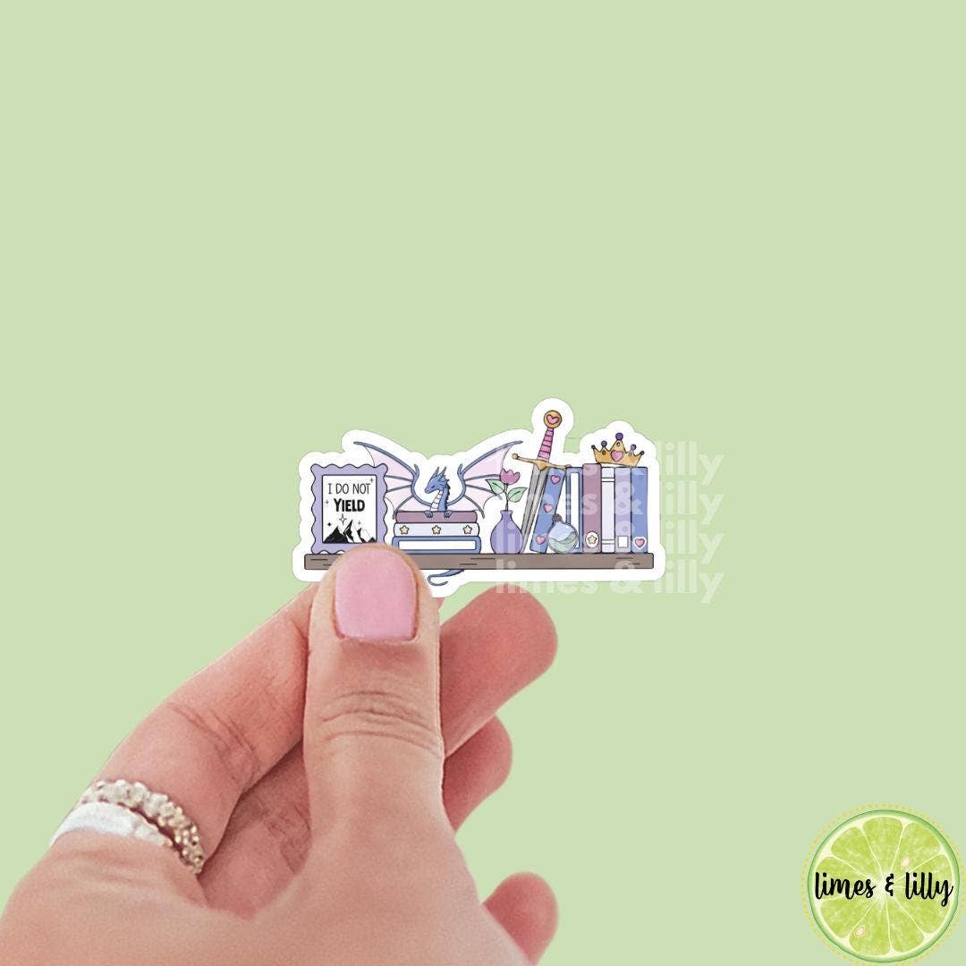 Hand holding a sticker with a design of books and a dragon on a light green background, with &