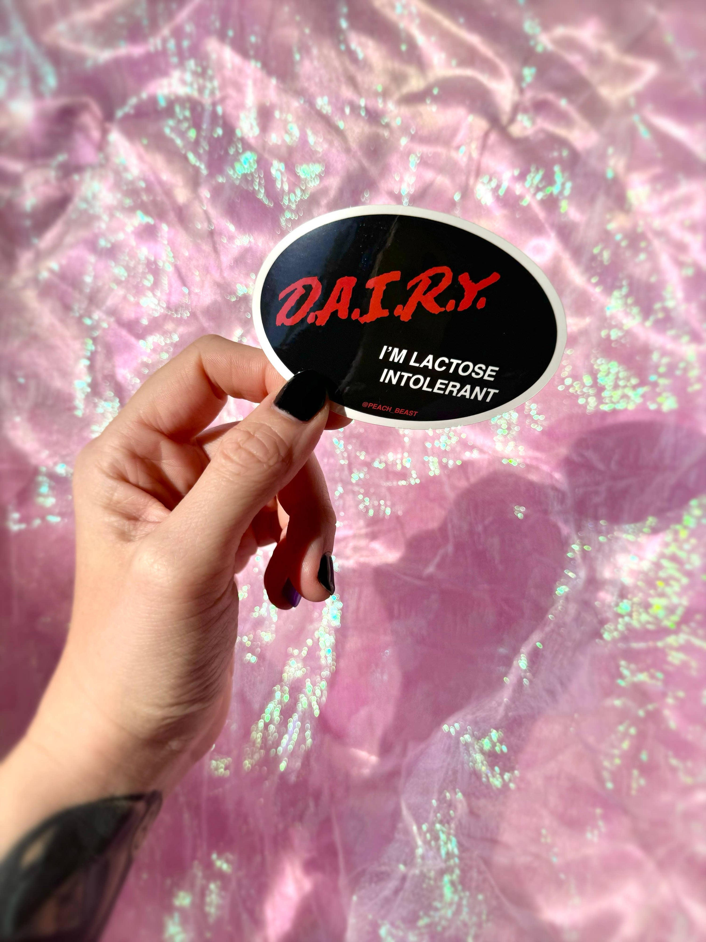 Hand holding a sticker with &