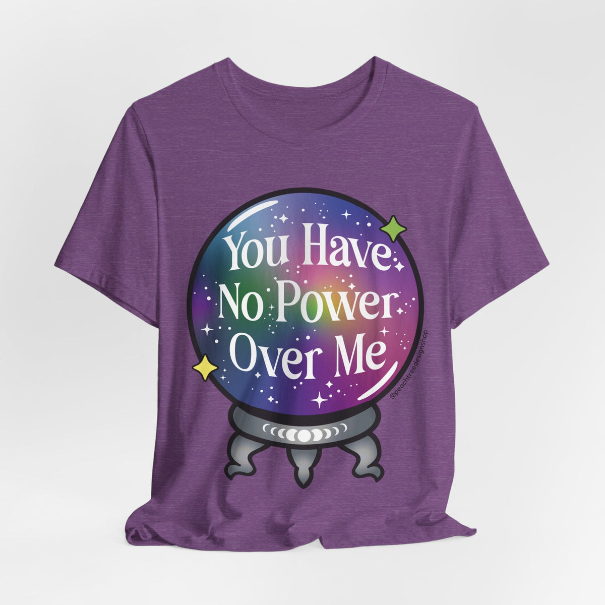 A purple short-sleeve t-shirt with a graphic of a crystal ball containing a galaxy pattern and the text &