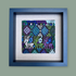 Framed textile art piece with geometric patterns and deer designs on a gray background