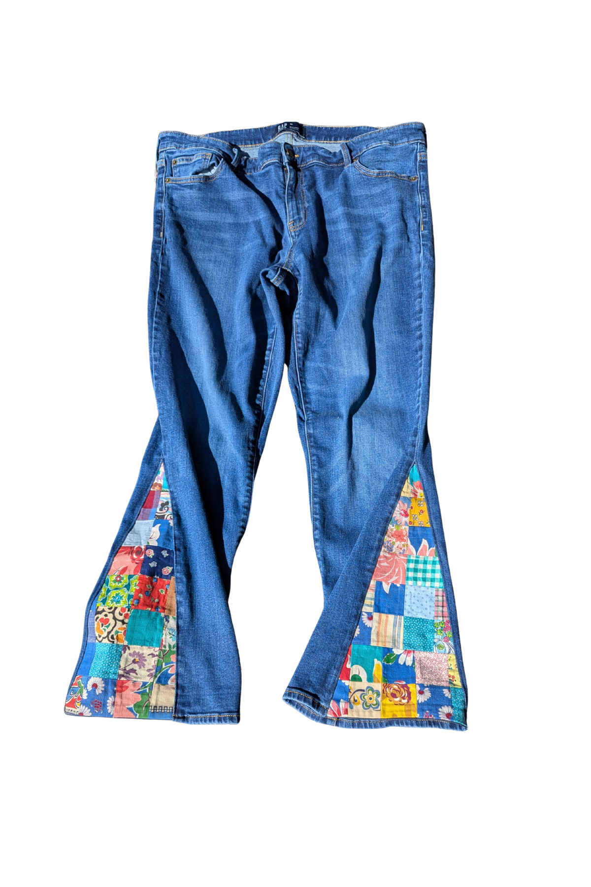 Blue jeans with colorful patchwork design on a white background