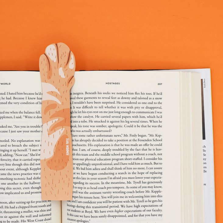 Wooden bookmark with animal design on an open book against an orange background