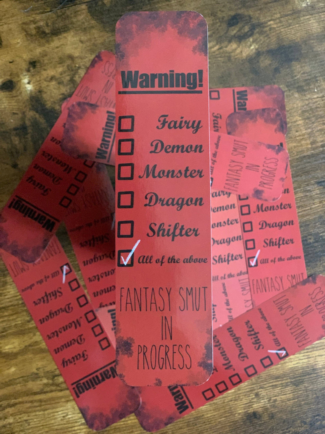 Red bookmarks with text and checkboxes on a wooden surface