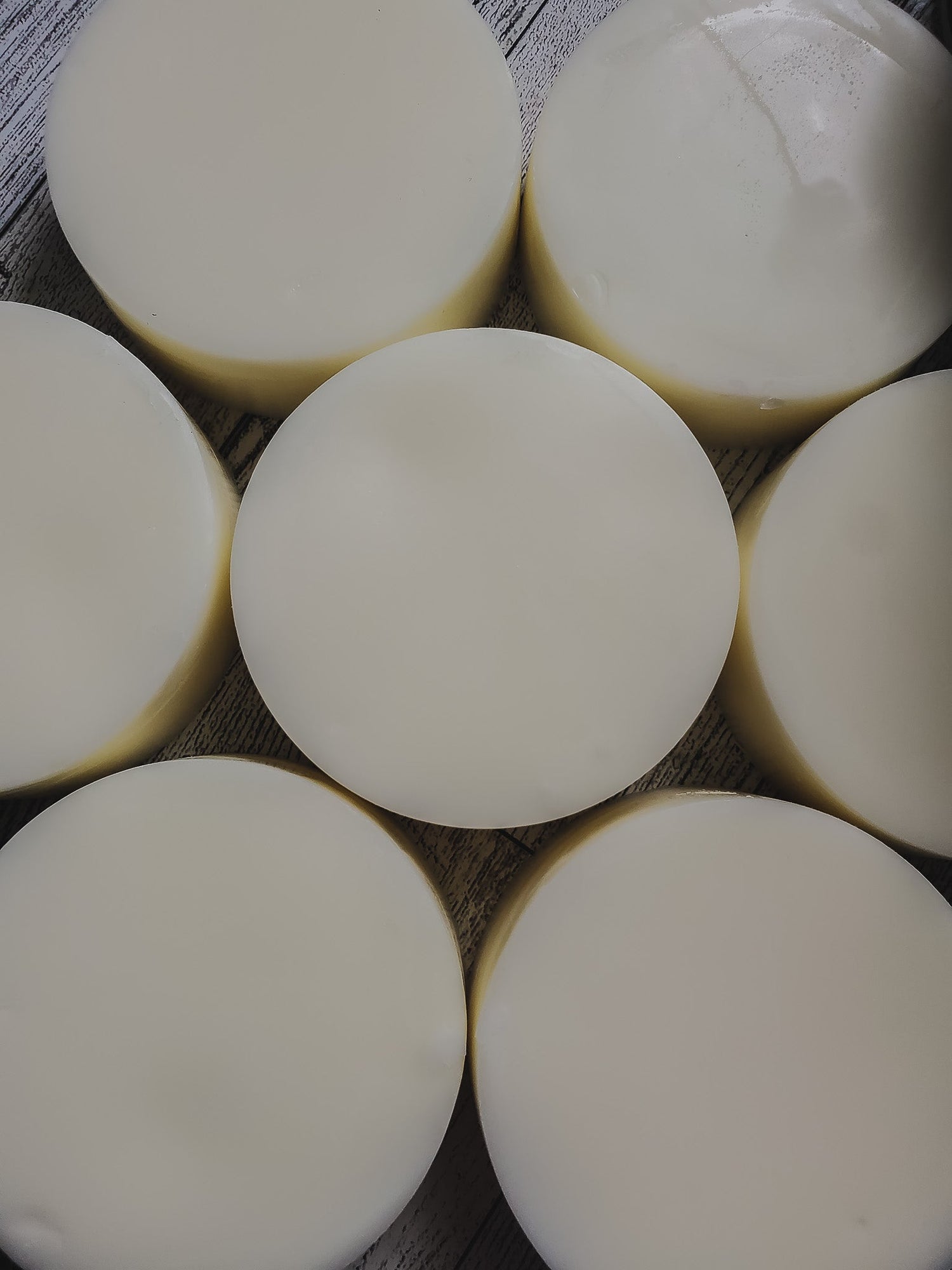 A collection of round conditioner bars arranged in a pattern on a textured background.