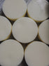 A collection of round conditioner bars arranged in a pattern on a textured background.