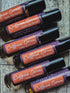 Roll-on bottles of caffeine serum under-eye serum with colorful labels on a dark background