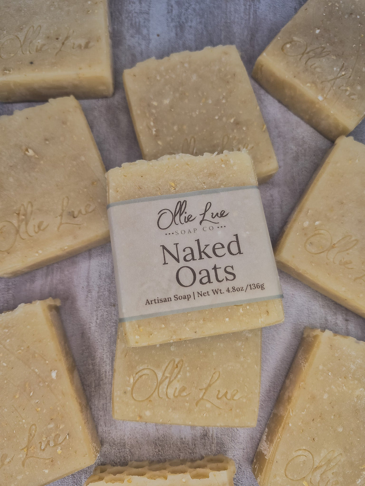 A bar of handmade soap wrapped in a beige paper label reading &