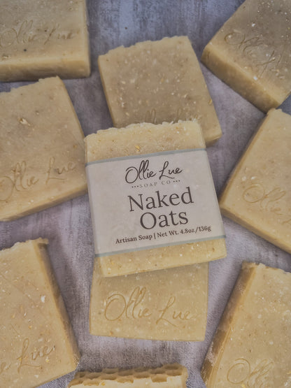 A bar of handmade soap wrapped in a beige paper label reading &