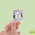 Hand holding a sticker of a candle with text on a light green background