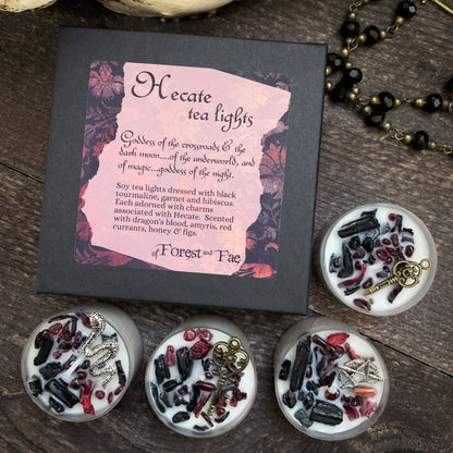 Hecate tea lights packaging with four decorated candles on a wooden surface
