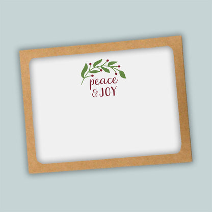 A white card with a brown frame, featuring a decorative wreath and the text "Peace &amp; Joy" in a cursive font.
