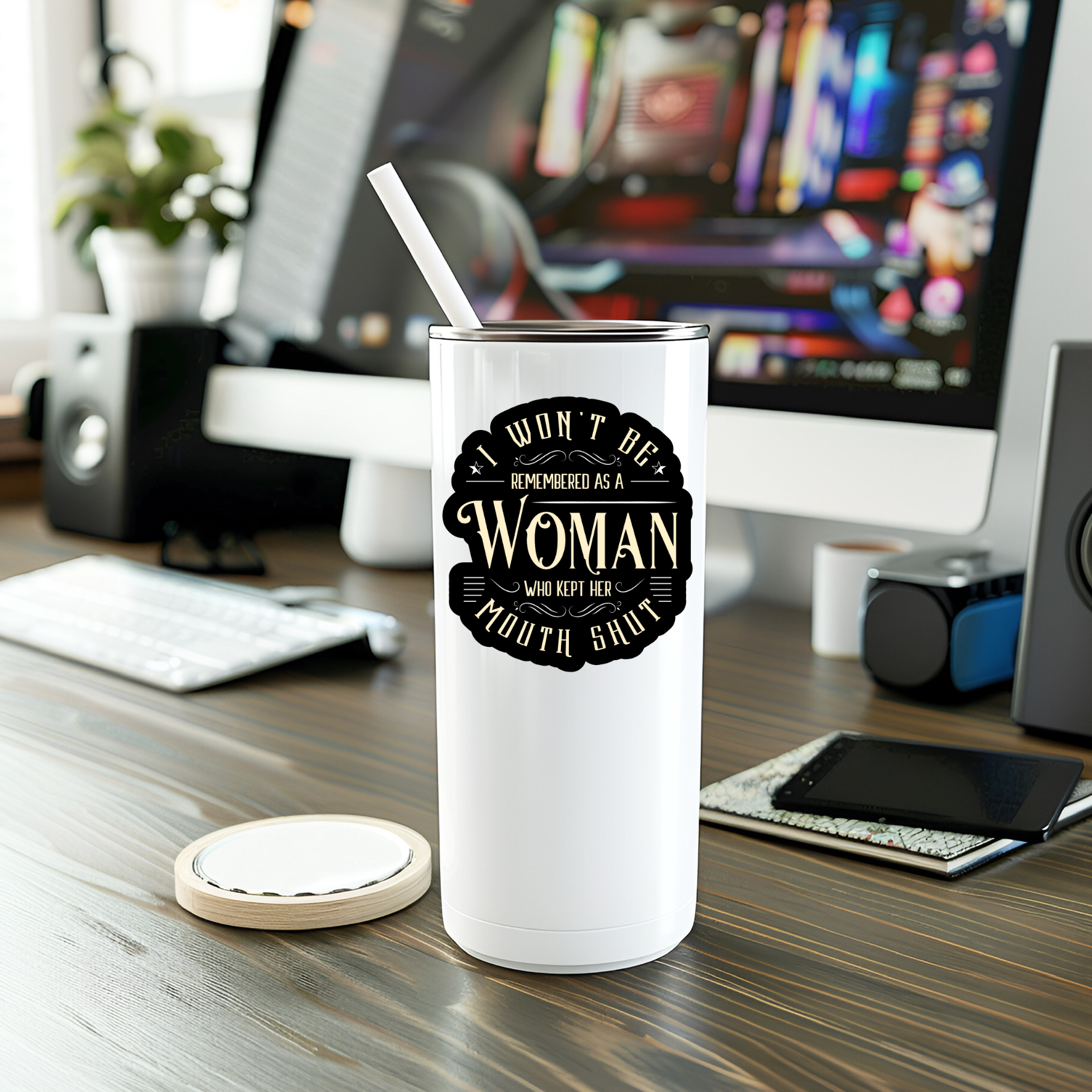 White tumbler with a black graphic on a desk with computer equipment in the background