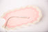 Necklace with a pendant on a pink and beige textured surface