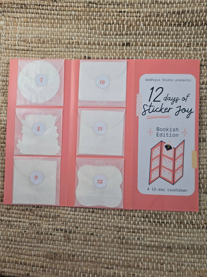12 days of Sticker Joy Bookish Edition packaging on a woven surface