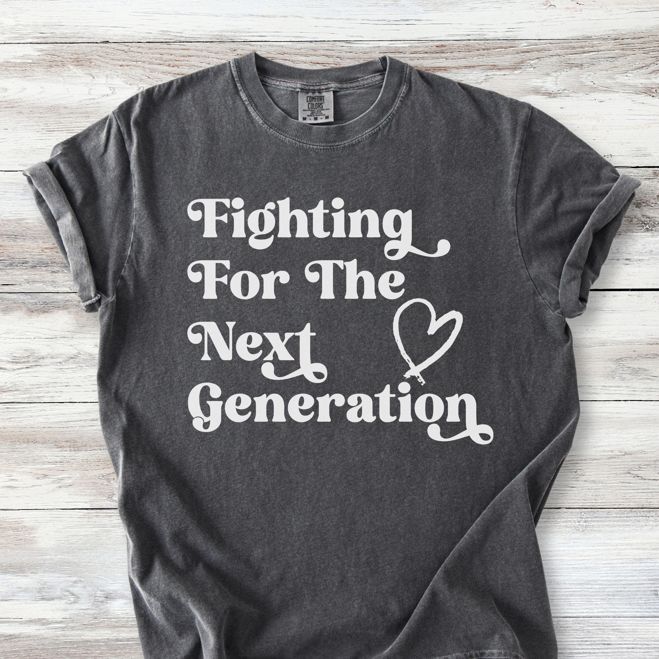 Comfort Colors unisex t-shirt with retro-style text reading "Fighting For The Next Generation" and a hand-drawn heart graphic.  Available in many colors, this listing includes Pepper, Bay, Espresso and Blossom *light pink)