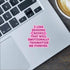 Laptop with a pink text sticker on the keyboard, next to a cup of coffee.