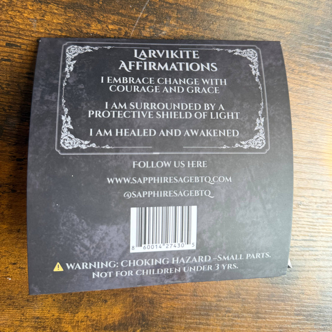 Back of a product packaging with text and a barcode on a wooden surface
