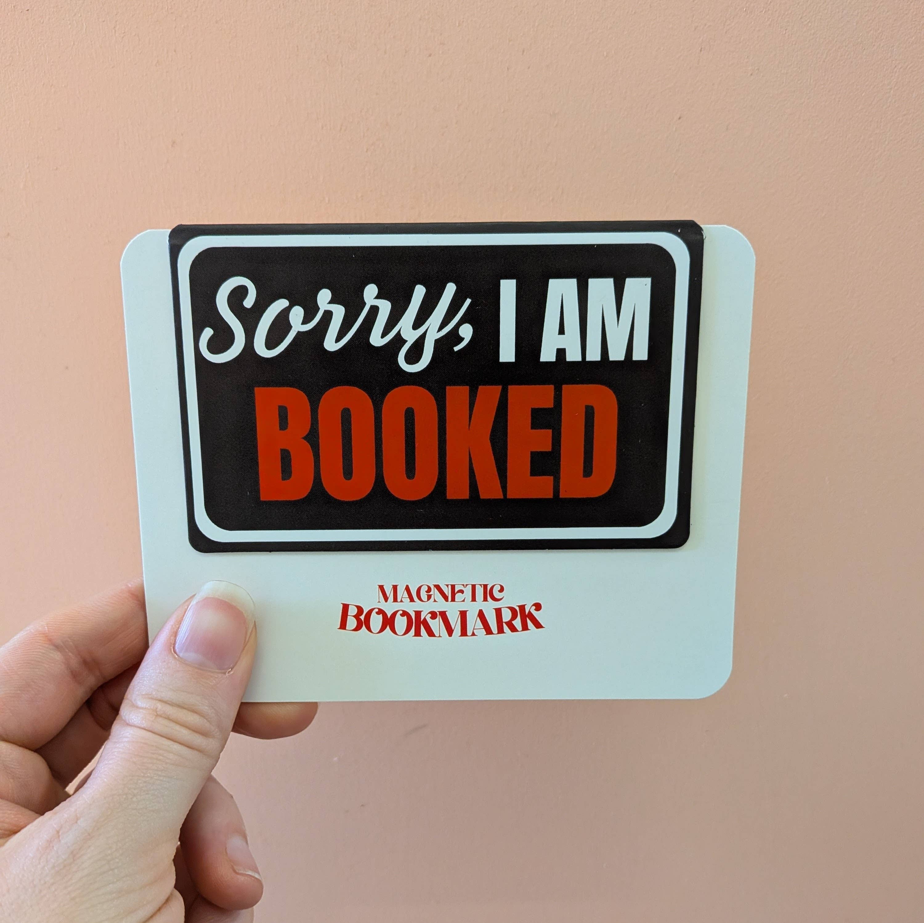 Hand holding a magnetic bookmark with &