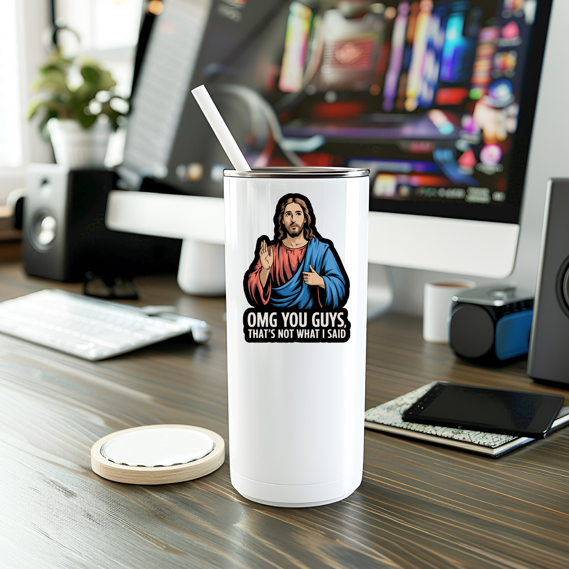 White tumbler with a graphic design on a desk with computer equipment in the background