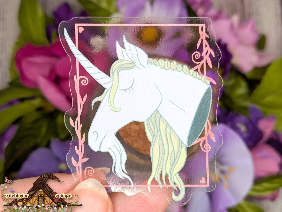 Unicorn-shaped clear acrylic standee held against a floral background