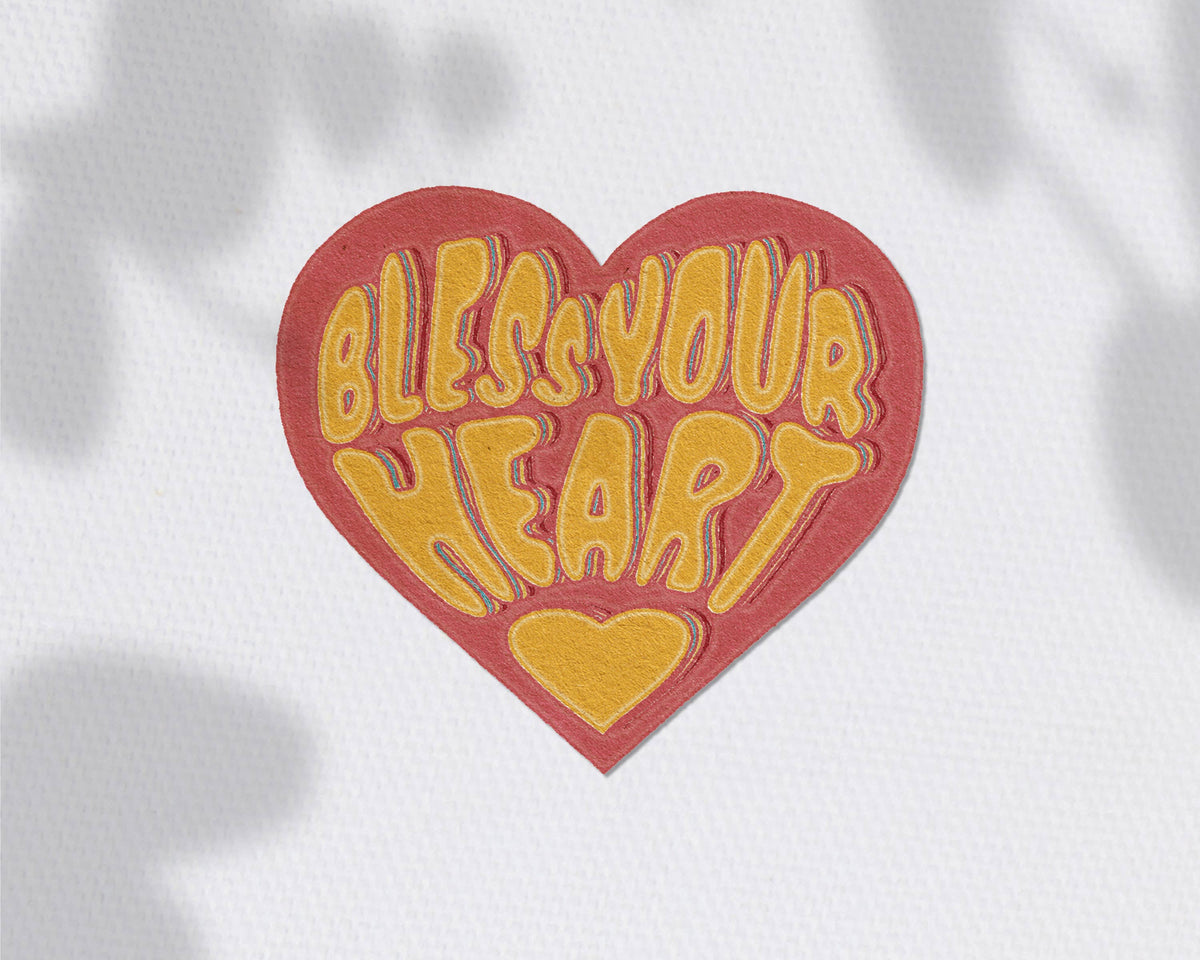 A heart-shaped patch with a red border and yellow text reading &