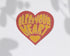 A heart-shaped patch with a red border and yellow text reading &