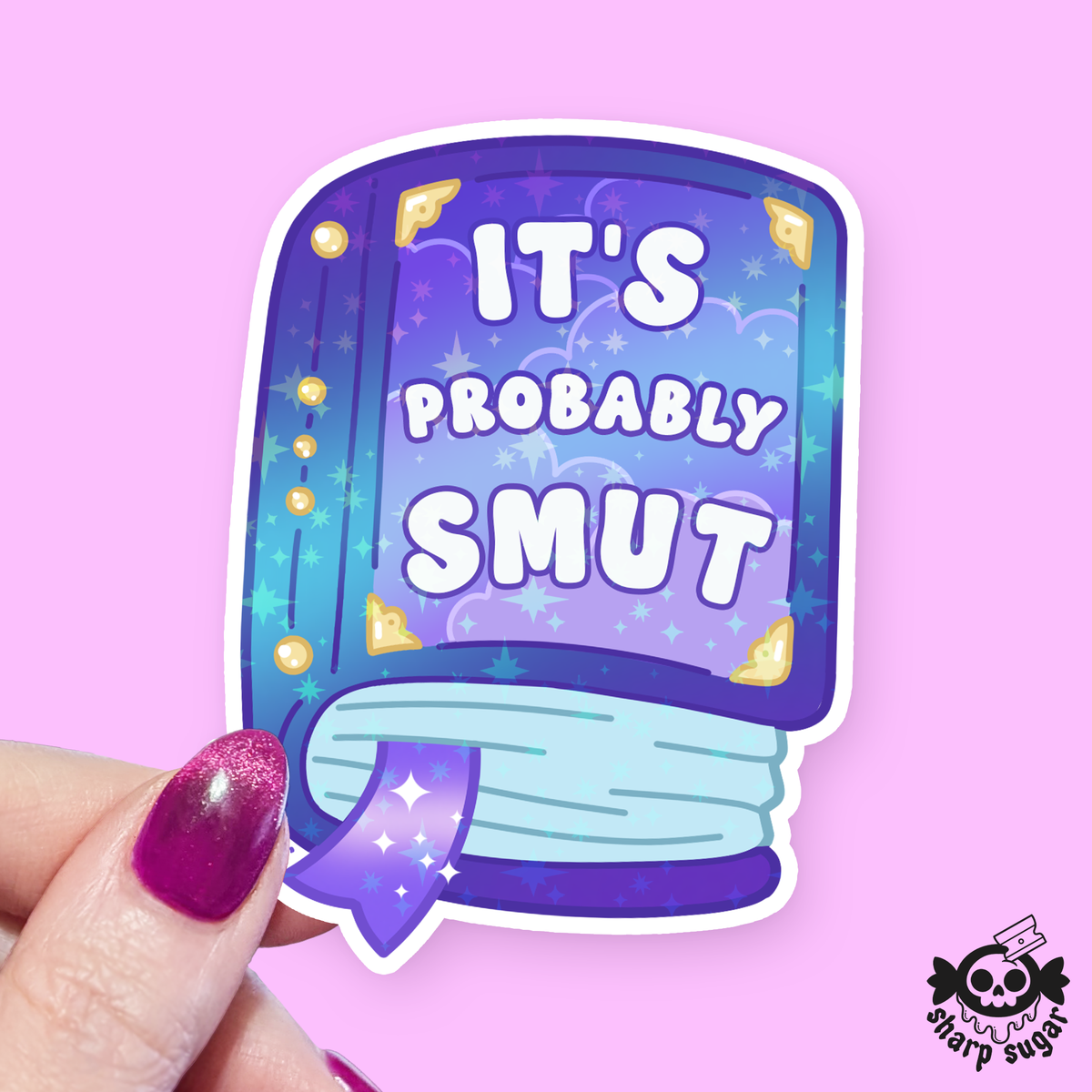 A die-cut sticker shaped like a book with the text &